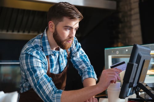 Retail staff member using a point of sale system in a specialist store
