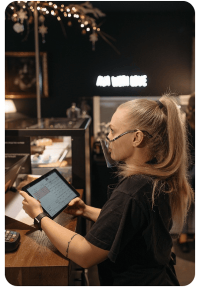 Retail staff member using a tablet-based POS system in a hospitality environment