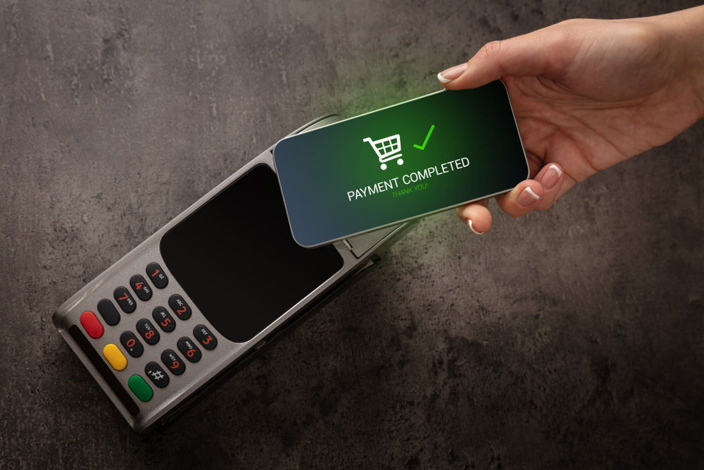 A contactless card payment being accepted on a payment terminal, representing offline transaction processing during an internet outage