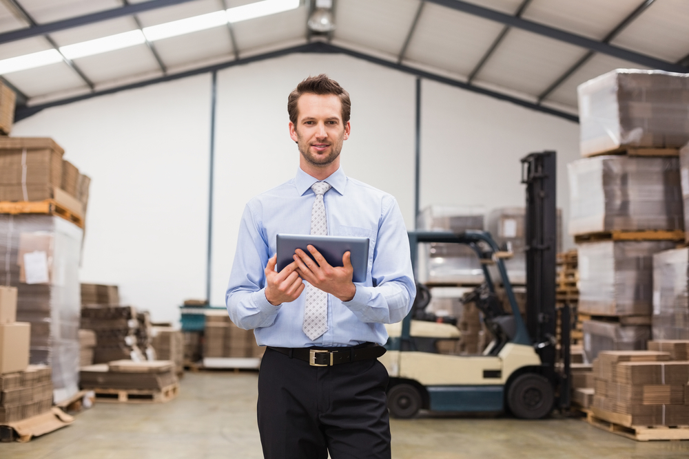 Manager reviewing operations data on a tablet in a warehouse