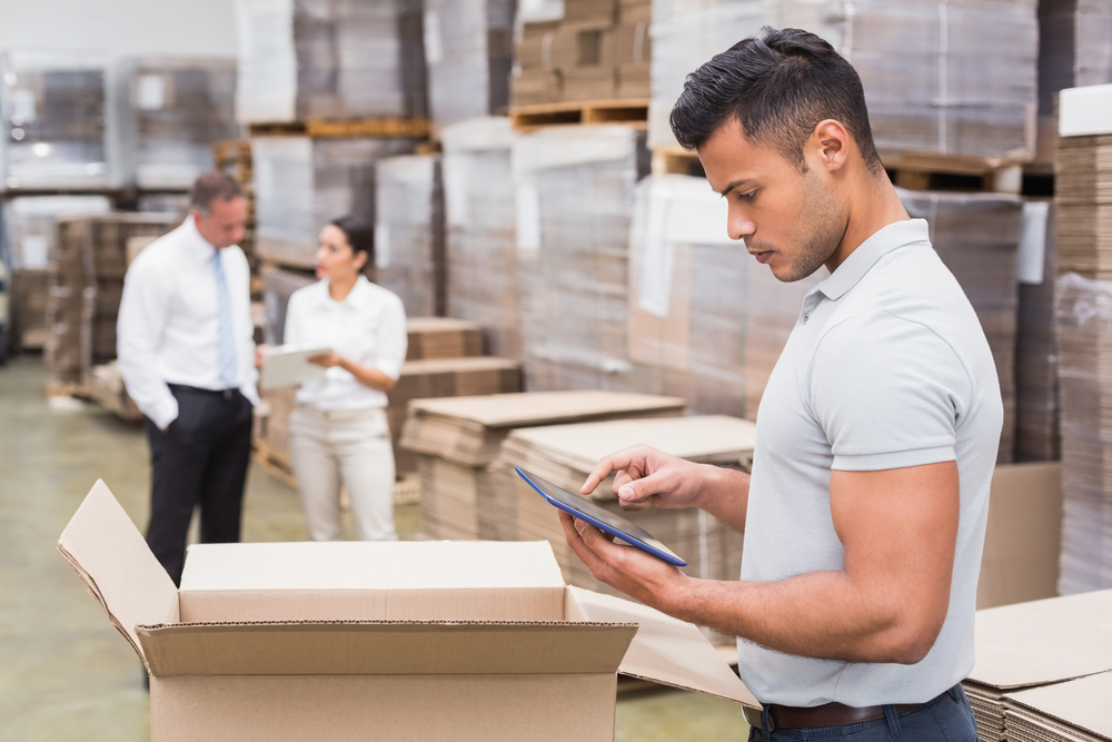Warehouse worker checking stock using a digital tablet