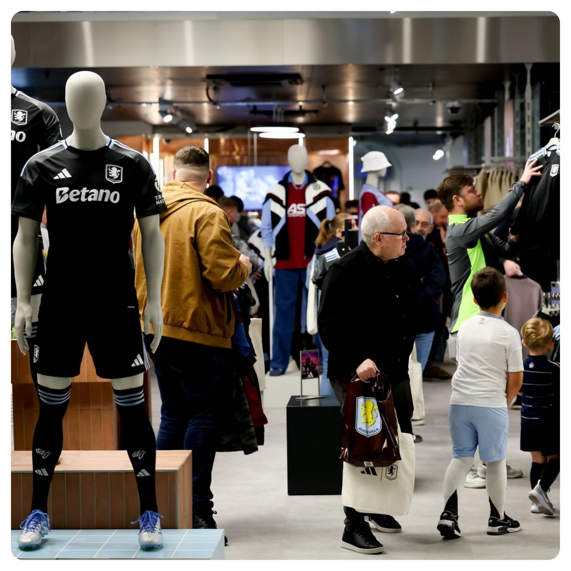 Sports merchandise store with fans browsing club kits and replica shirts